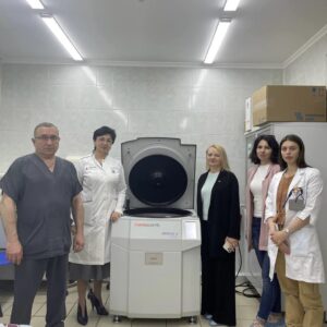 Медичні працівники та представники фонду «Запорука» поруч із новою центрифугою у Національному інституті раку.