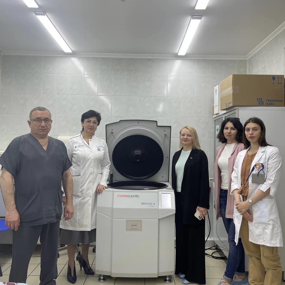 Медичні працівники та представники фонду «Запорука» поруч із новою центрифугою у Національному інституті раку.
